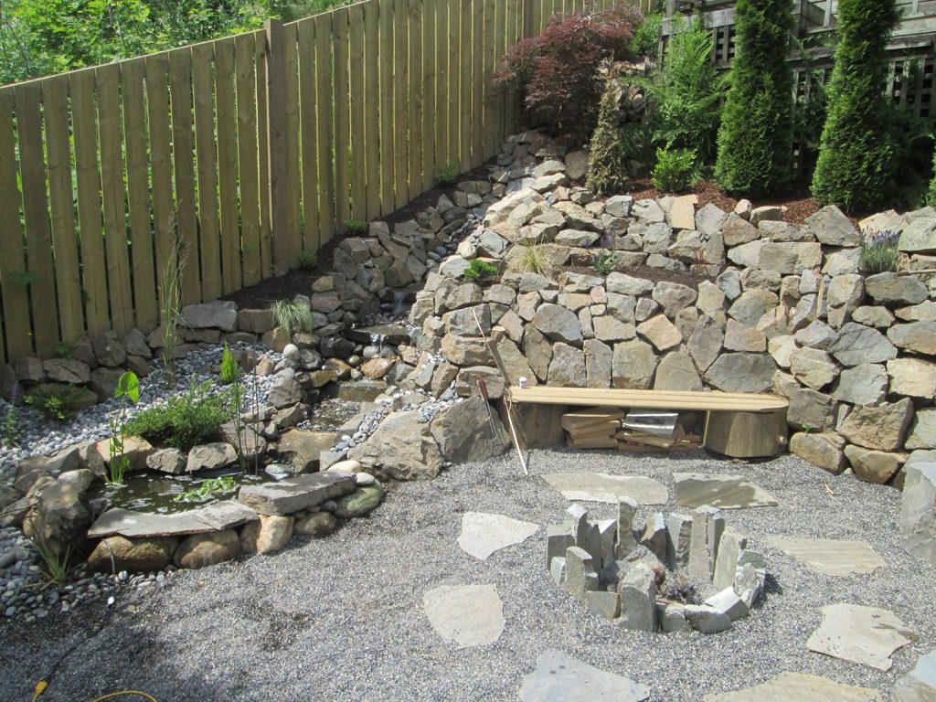 Backyard stone fire pit and bench