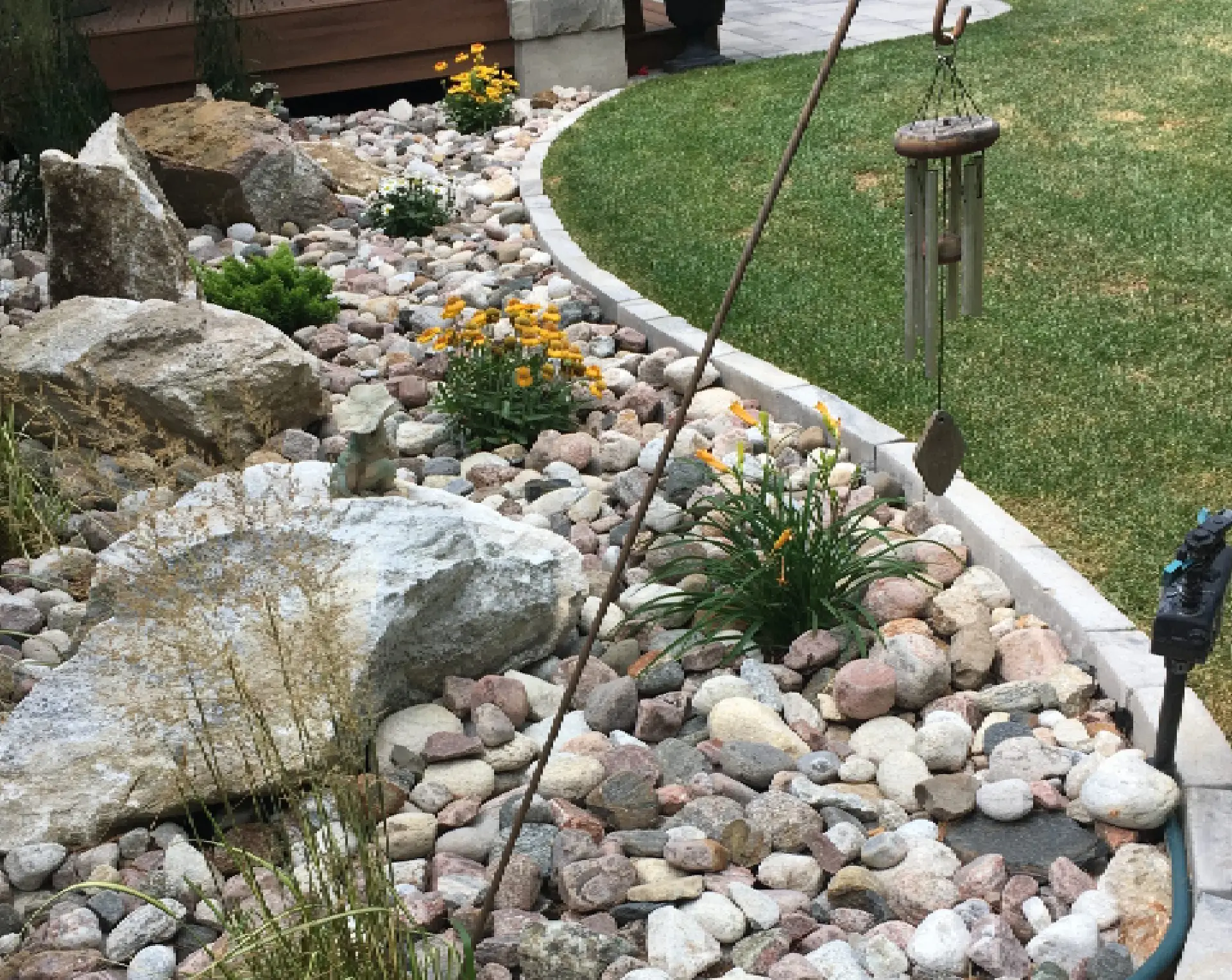 Rock garden with flowers and wind chimes