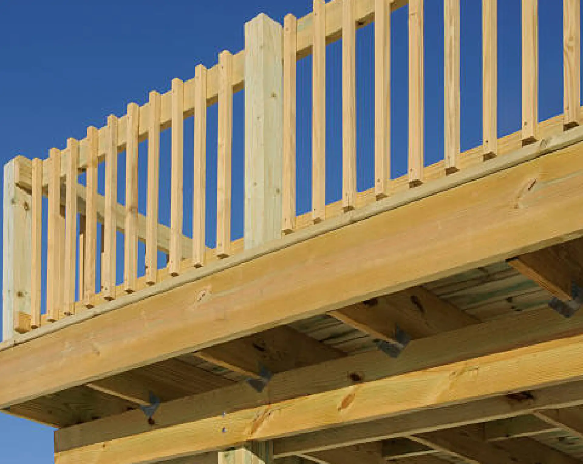 Wooden deck railing under blue sky
